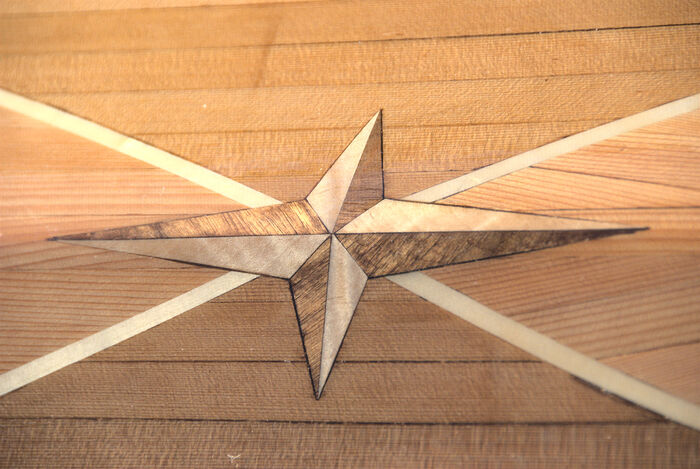 The star (compass rose?) is curly maple and black walnut